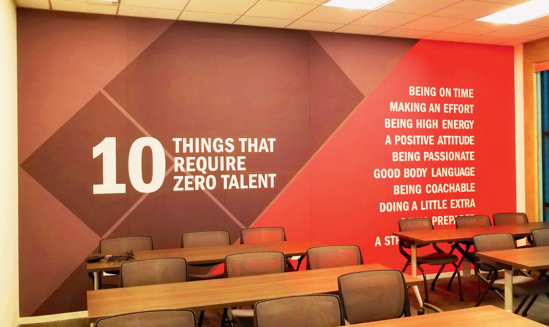 Facility training room wall wrapped in a printed red and grey graphic with large typography